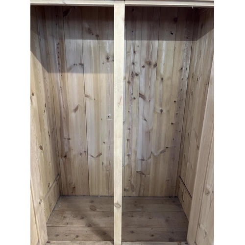 1517 - An antique pine 2 door wardrobe with central drawer and shaped top. Ceramic knob handles and decorat... 