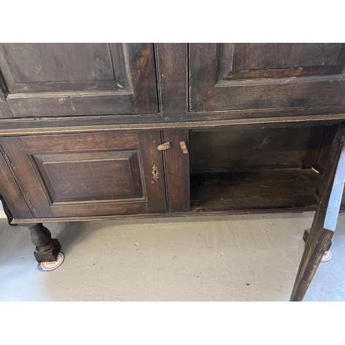 1518 - A Georgian dark wood 4 door cupboard with fixed interior shelves, raised on turned front legs. Origi... 