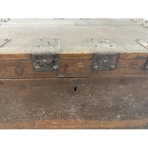 1520 - An antique dark wood storage chest with metal banding and drop down handles. Complete with lock, key... 