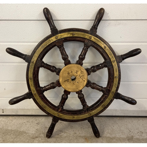 1431 - An antique brass bound dark wood maritime ships wheel with 8 turned spokes. Approx. 76cm diameter.