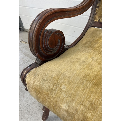 1528 - A Victorian wooden framed armchair with scroll detail to arms and carved legs. Velvet upholstered se... 