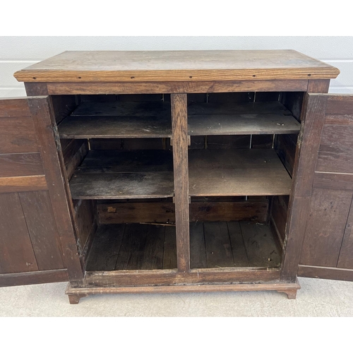 1529 - An antique dark wood 2 door cupboard with fixed interior shelving and panelled doors and sides. Appr... 