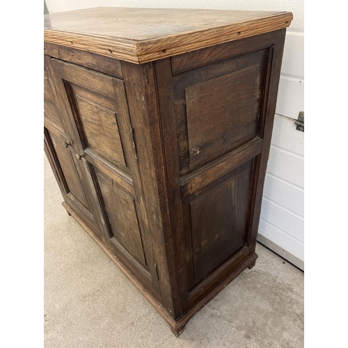 1529 - An antique dark wood 2 door cupboard with fixed interior shelving and panelled doors and sides. Appr... 