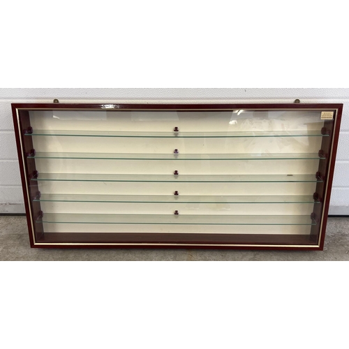 1433 - A modern slim line wall hanging display cabinet with glass shelves. Polished mahogany finish with cl... 