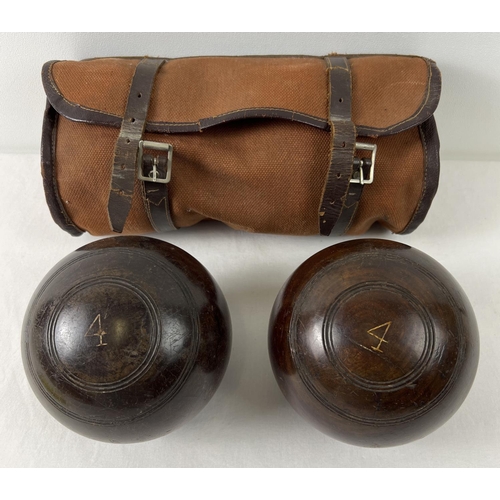 1436 - A pair of vintage wooden lawn bowls No. 4, with original canvas and leather case.