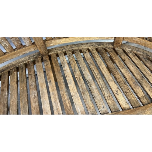 1487 - A large Windsor curve backed teak garden bench with slatted back and seat and serpentine shaped fron... 