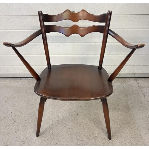 1541 - An Ercol mid century dark wood carver dining arm chair with shaped back and splayed legs. Stamped to... 