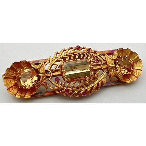 132 - A vintage 22ct yellow gold brooch set with 3 large yellow topaz stones and small ruby cabochons. A b... 