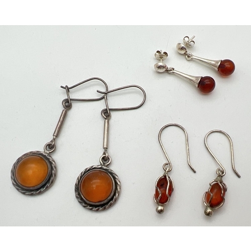 1073 - 3 pairs of modern silver and amber drop style earrings in various designs. All have silver marks to ... 