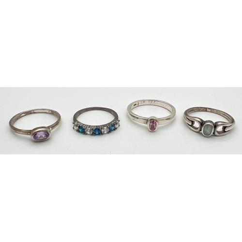 8 - 4 stone set silver dress rings in varying styles and sizes. To include blue and clear stone set eter... 