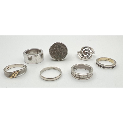 20 - 7 silver rings mostly in a band style. Lot includes a 1967 sixpence set in a vintage silver ring and... 