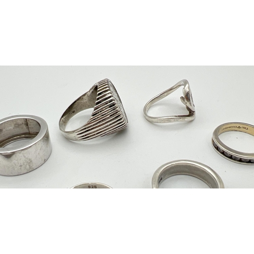 20 - 7 silver rings mostly in a band style. Lot includes a 1967 sixpence set in a vintage silver ring and... 