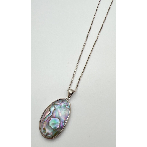 42 - An oval shaped Abalone shell pendant set in silver, on a 20