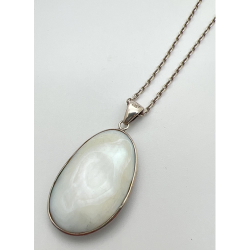 42 - An oval shaped Abalone shell pendant set in silver, on a 20