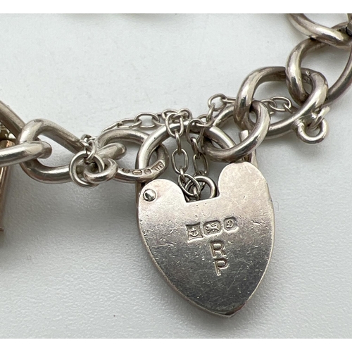 44 - A vintage silver charm bracelet with 6 charms, padlock and safety chain. Charms comprise: Wooden hou... 