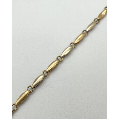 67 - A 7.5 inch 9ct duo coloured gold bracelet with lobster claw clasp. Alternating small oval links in w... 