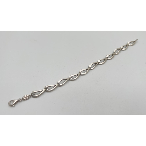 75 - A Fossil silver bracelet with teardrop shaped links and lobster claw clasp. Approx. 7.5 inches long.... 