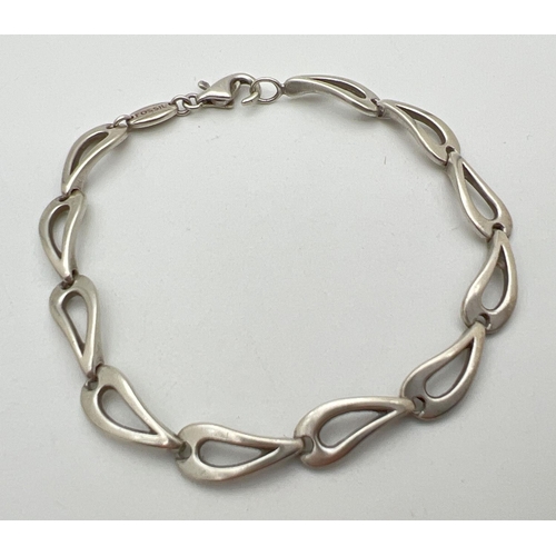 75 - A Fossil silver bracelet with teardrop shaped links and lobster claw clasp. Approx. 7.5 inches long.... 