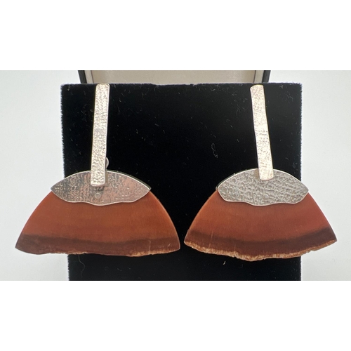 76 - A pair of contemporary style drop silver and resin earrings. Semi circle shaped brown resin pieces c... 