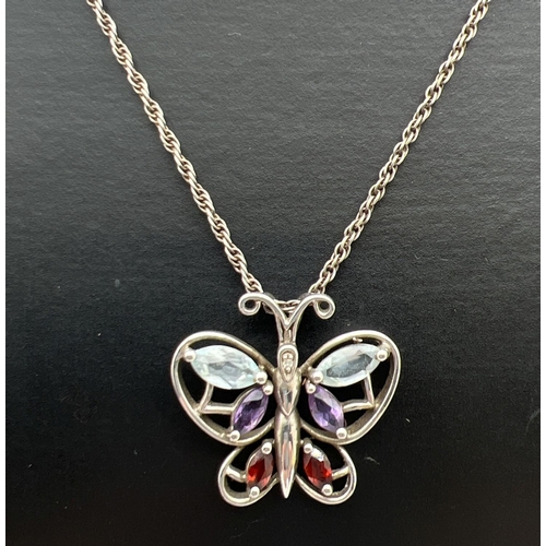 79 - A silver butterfly pendant set with a diamond, amethyst, blue topaz and garnets. On an 18