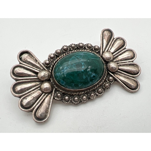 80 - A silver modern design Floral style brooch set with a central oval green stone. Silver mark to back.... 