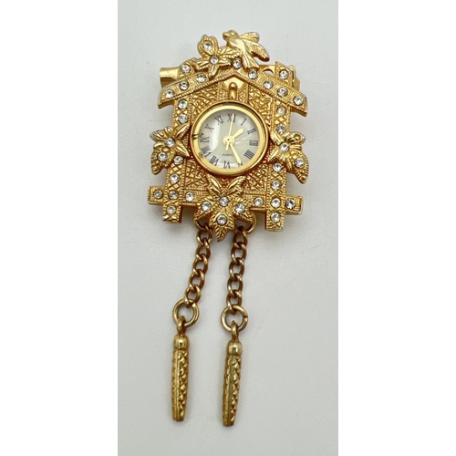 110 - A gold tone Cuckoo clock pendant/brooch set with clear stones, by ETC Co. Ltd. Floral and bird desig... 