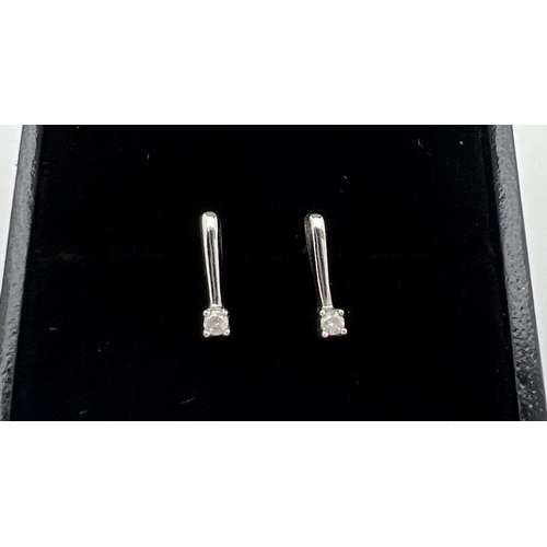 114 - A pair of modern design 9ct white gold earrings each set with a 0.05ct diamond. Gold and diamond mar... 