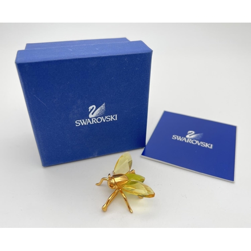 115 - A boxed Swarovski Crystal flying insect brooch from the 'Paradise Bugs' range. Gold plated silver wi... 