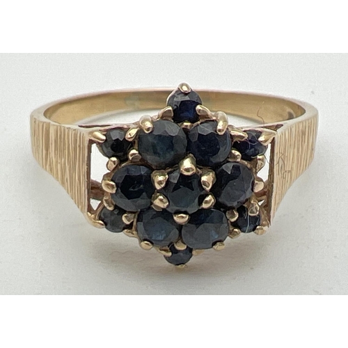 128 - A vintage 9ct gold sapphire cluster dress ring. Central round cut sapphire surrounded by 6 same size... 