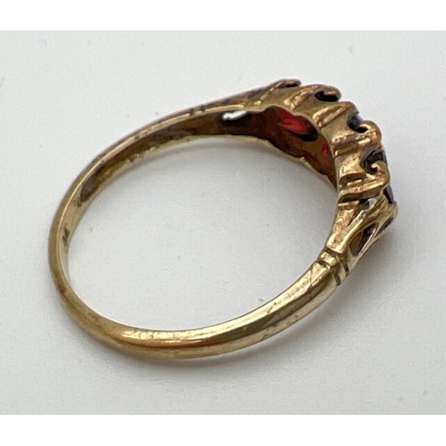 161 - A vintage 9ct gold garnet set trilogy ring with scroll decoration to mount. Size Q. Total weight app... 