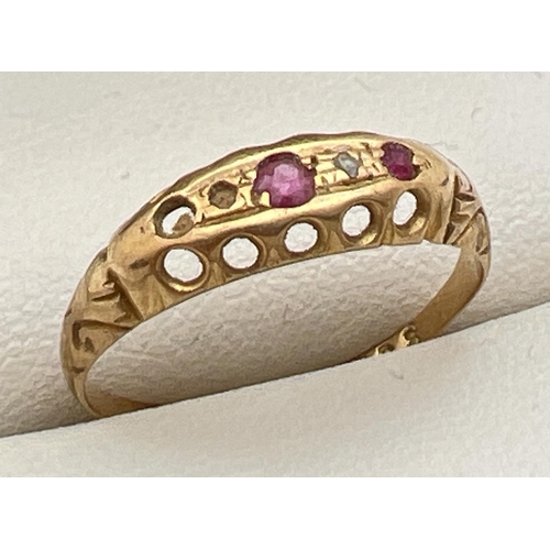 165 - A vintage 18ct gold ruby and diamond gypsy style ring with scroll decoration to shoulders. One small... 