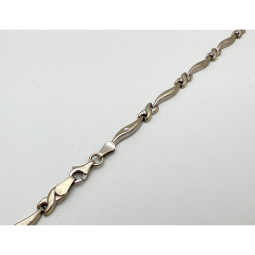 167 - A 9ct white gold wave and cross link bracelet, for scrap or repair - one link broken. Gold mark to f... 