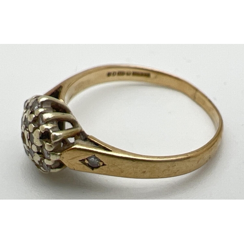 169 - A small 9ct gold diamond cluster ring with a single small diamond set to each shoulder (two small st... 