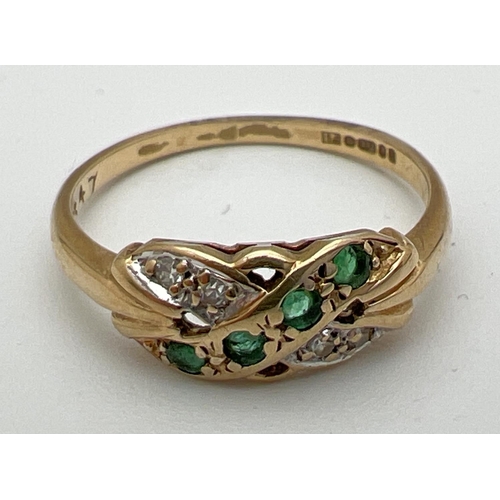 170 - A 9ct gold diamond and emerald set dress ring with crossover style mount. Full hallmarks to inside o... 