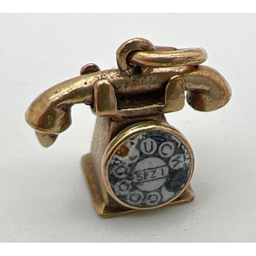 180 - A 9ct gold pendant/charm modelled as a telephone with enamel detail to dial. Gold marks to base and ... 