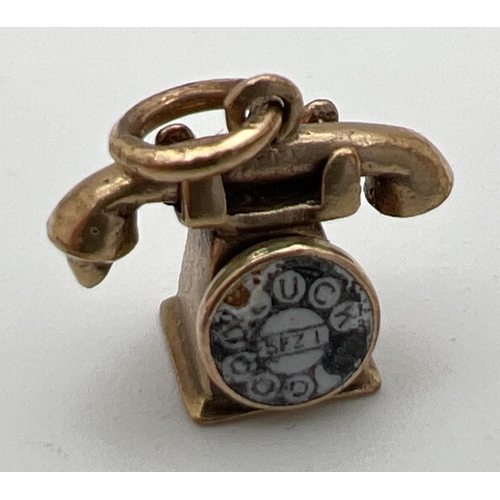 180 - A 9ct gold pendant/charm modelled as a telephone with enamel detail to dial. Gold marks to base and ... 