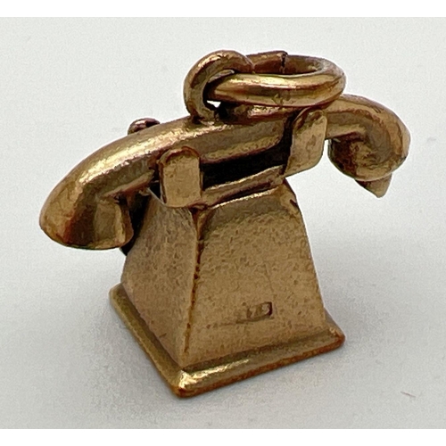 180 - A 9ct gold pendant/charm modelled as a telephone with enamel detail to dial. Gold marks to base and ... 