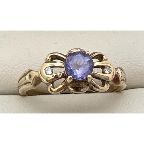 185 - A 9ct gold amethyst and diamond set dress ring. Central round cut amethyst with 2 small diamonds eit... 