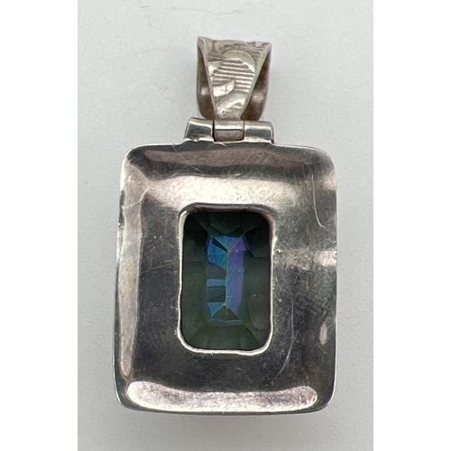 203 - A silver pendant set with a large square cut mystic topaz stone. Detailed pattern to mount and bale.... 