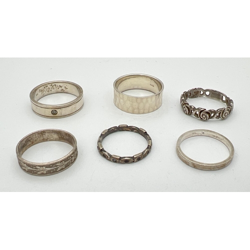 206 - 6 silver and white metal band style rings. To include hammered effect, floral design and a plain ban... 