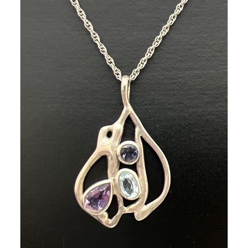 210 - A contemporary design silver pendant set with an oval cut blue topaz, round cut iolite and a teardro... 