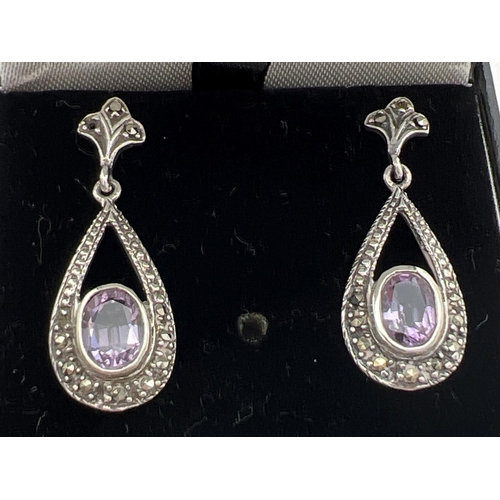 212 - A boxed pair of silver marcasite and amethyst set drop earrings with fleur de lis design to posts. O... 