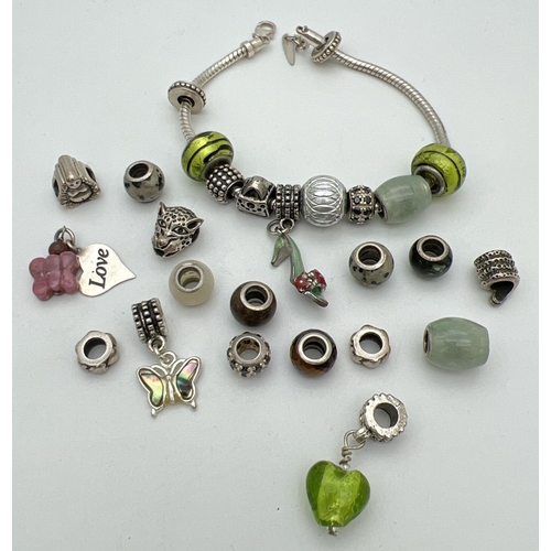 214 - A silver charm bracelet with lobster claw clasp together with a quantity of charm beads. To include ... 