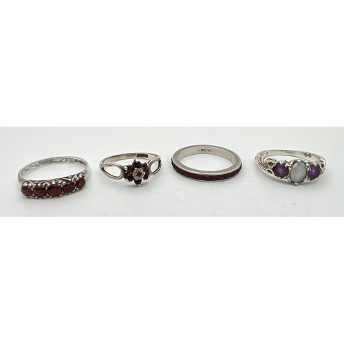 226 - 4 silver stone set rings. A full eternity ring set with garnets, a small cluster ring set with garne... 