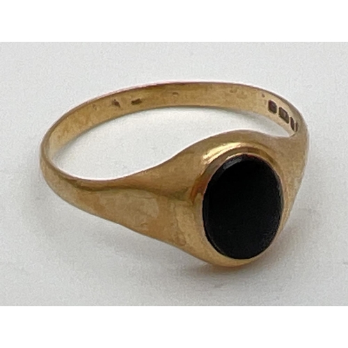 245 - A 9ct gold signet ring set with an oval of black onyx. Hallmarks to inside of band. Size O, total we... 