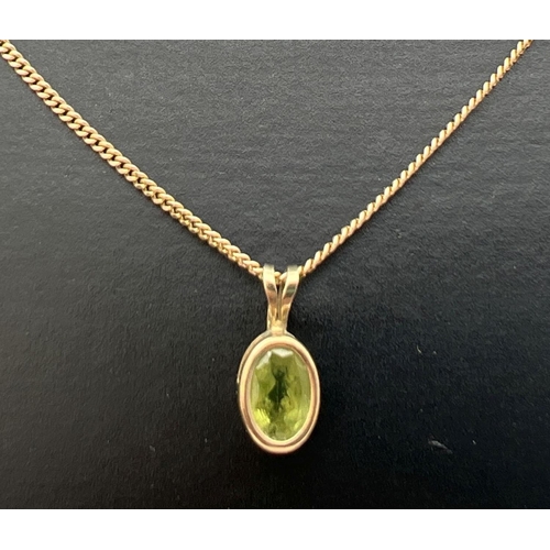 290 - A 9ct gold oval shaped bezel set Peridot pendant, on an 18