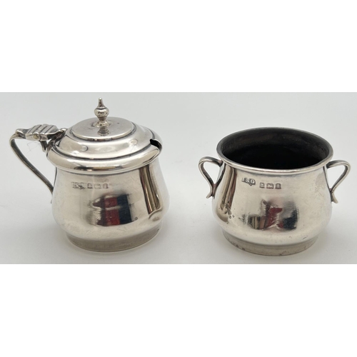 1117 - An Edwardian silver 2 piece cruet - 2 handled salt together with a hinge lidded mustard pot. Both fu... 