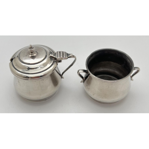 1117 - An Edwardian silver 2 piece cruet - 2 handled salt together with a hinge lidded mustard pot. Both fu... 