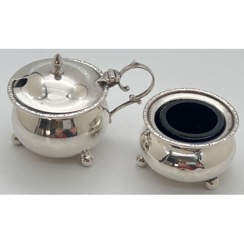 1118 - An early 20th century silver 2 piece cruet of bulbous form raised on tripod ball feet and with engra... 