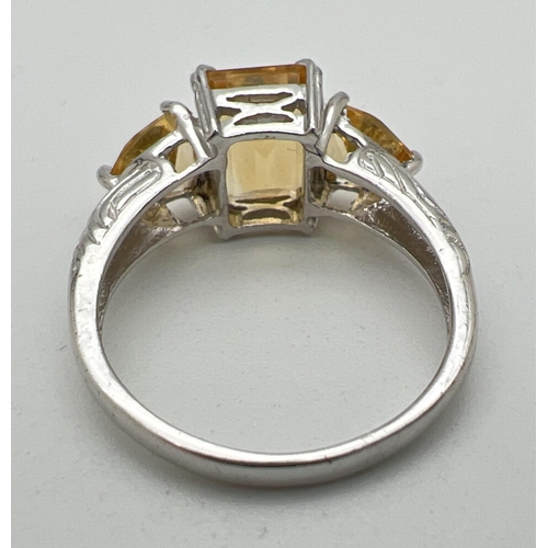 1021 - A silver and citrine 3 stone cocktail ring, set with square cut central stone flanked by 2 trilliant... 